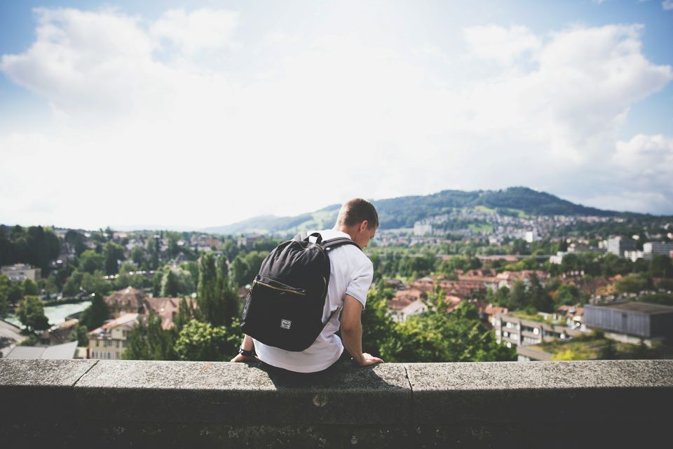 Man sitting on a grey wall